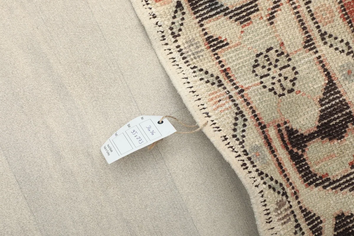 Detail of the rug's edge with a size tag, showing the 3'1" x 8'11" dimensions and material information.