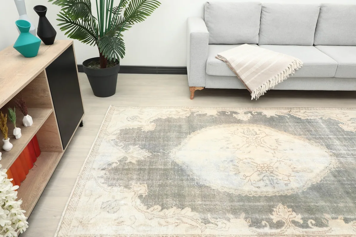 Angle view of the rug in a living room, highlighting the central medallion and faded colors