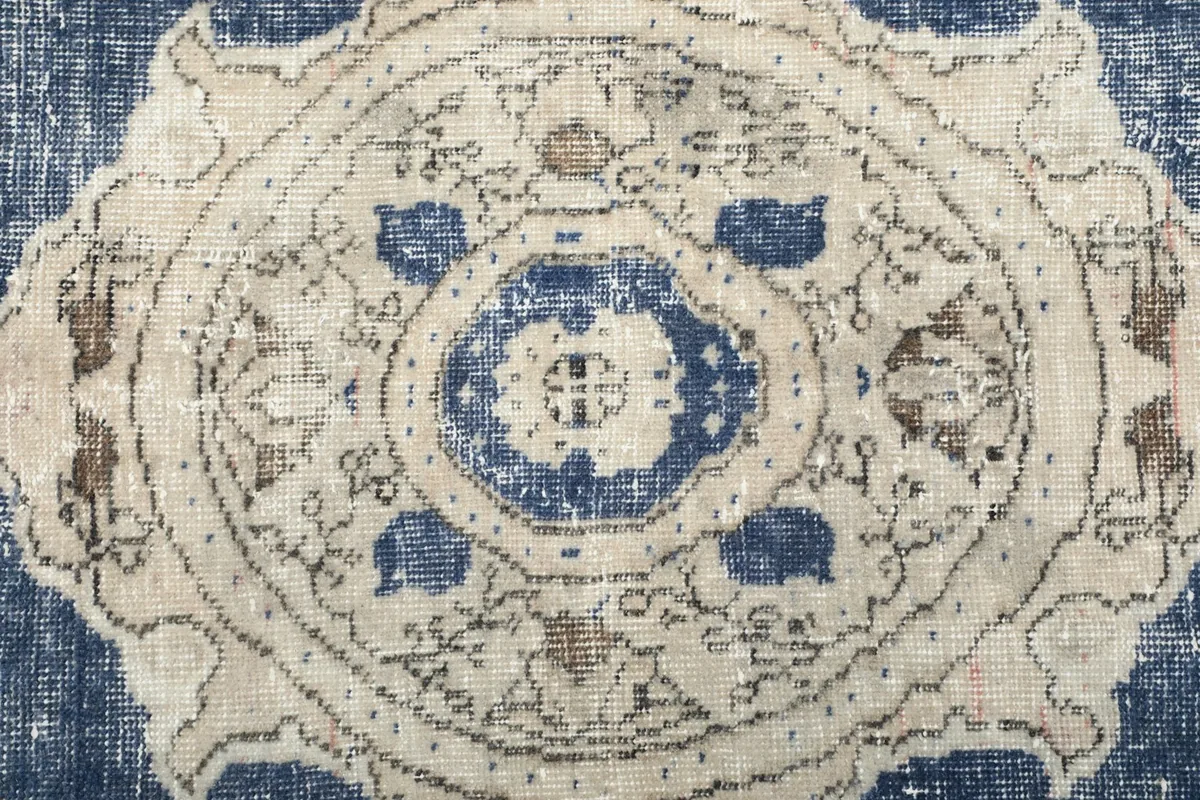 Close-up of the intricate patterns within the central medallion of the vintage rug.
