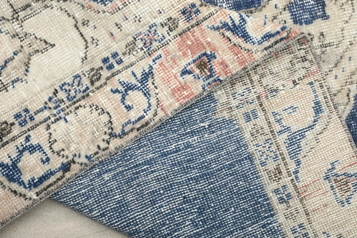 Close-up showing the reverse side of the rug, revealing the cotton foundation and knotting.