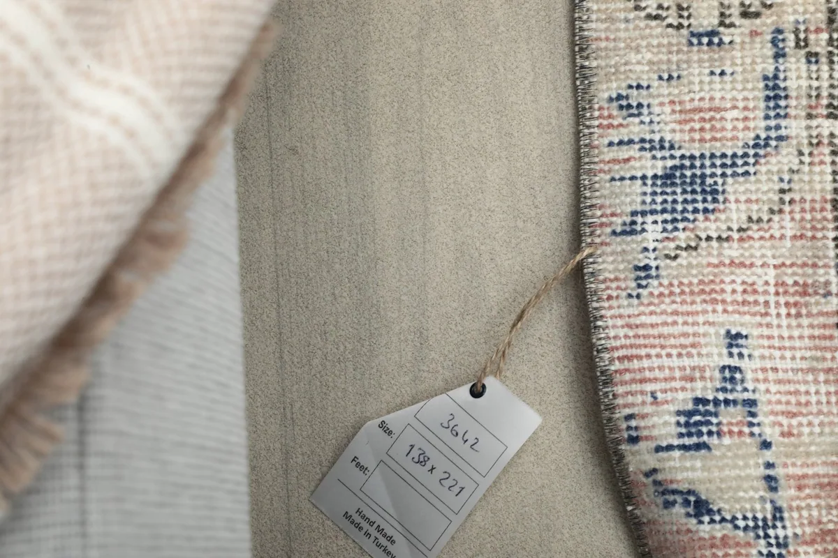 Rug label showing the dimensions 138 x 221 cm and origin, next to the rug's edge.