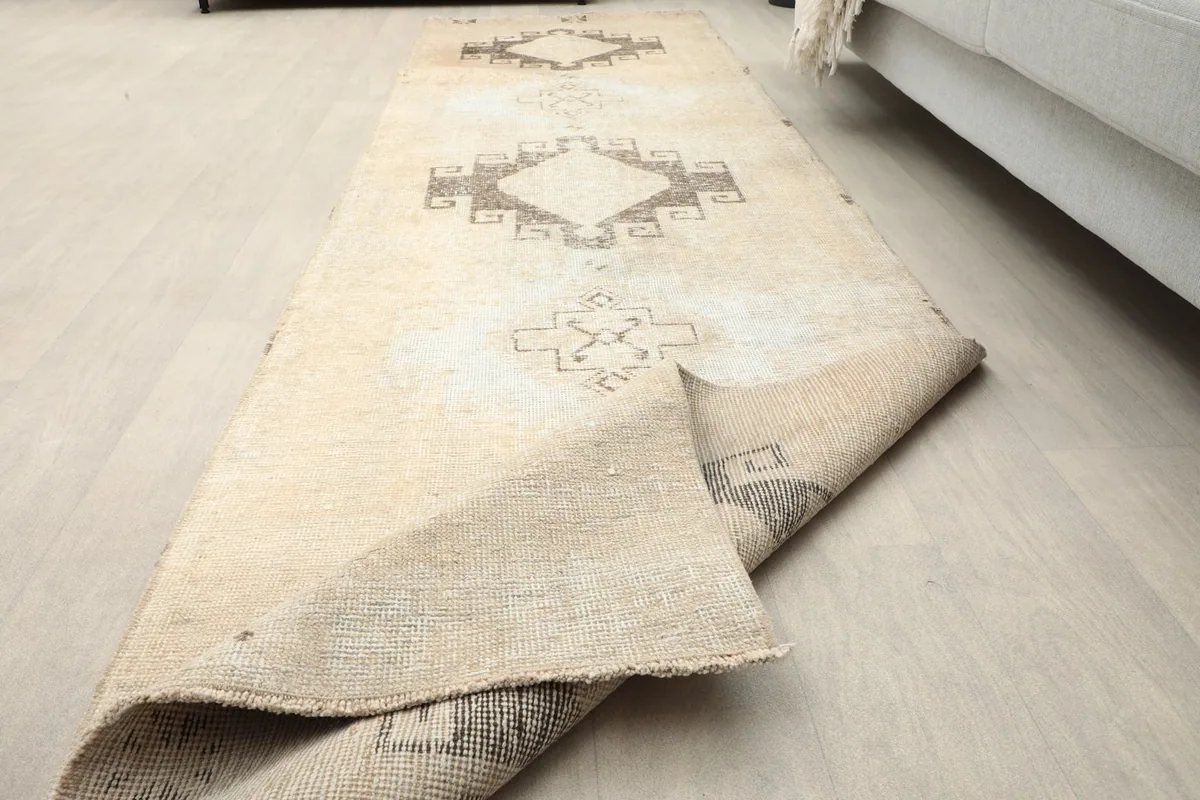 Angled view of the runner rug with a corner slightly lifted, showcasing its flexibility.