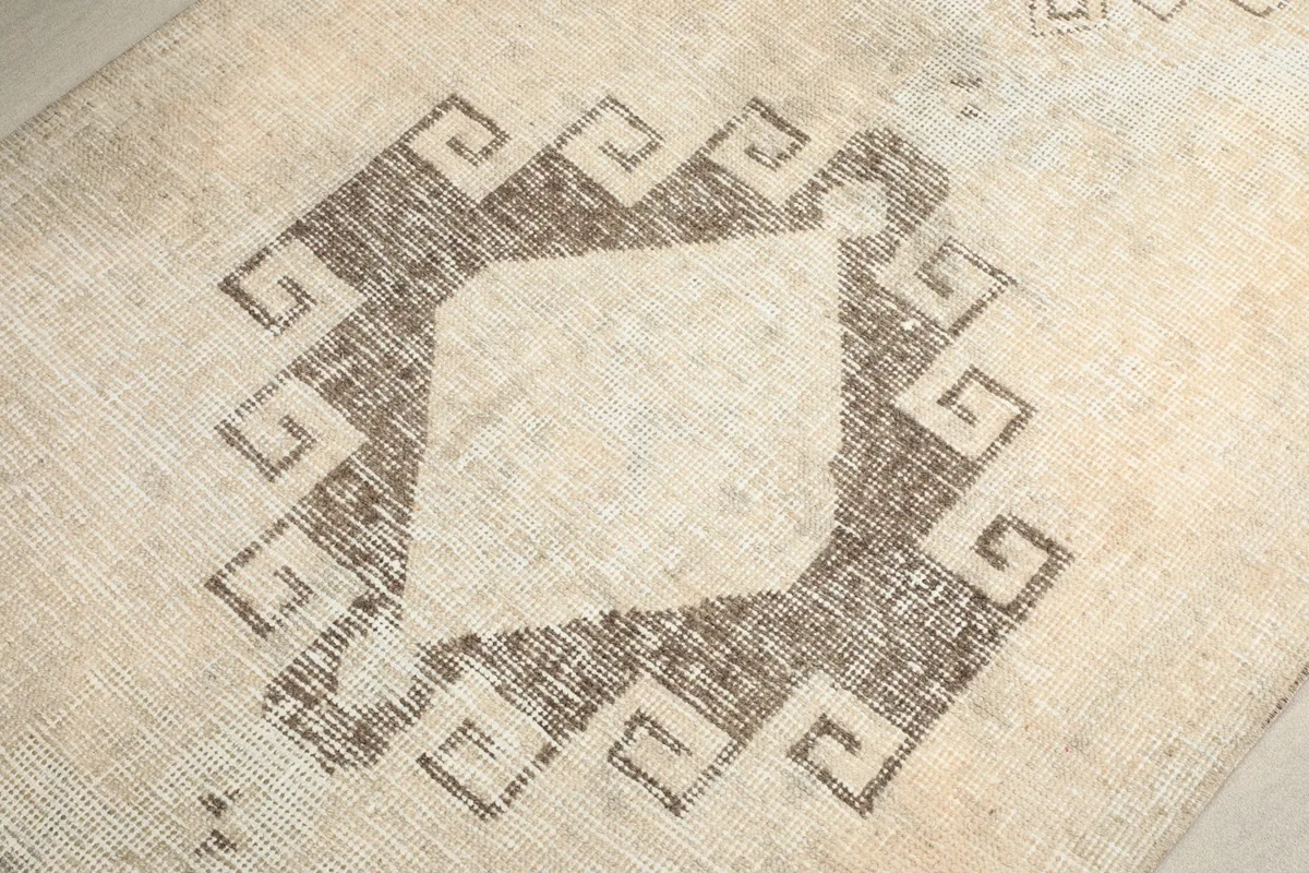 Macro detail of the hand-knotted wool pile and the intricate lines of a tribal motif.