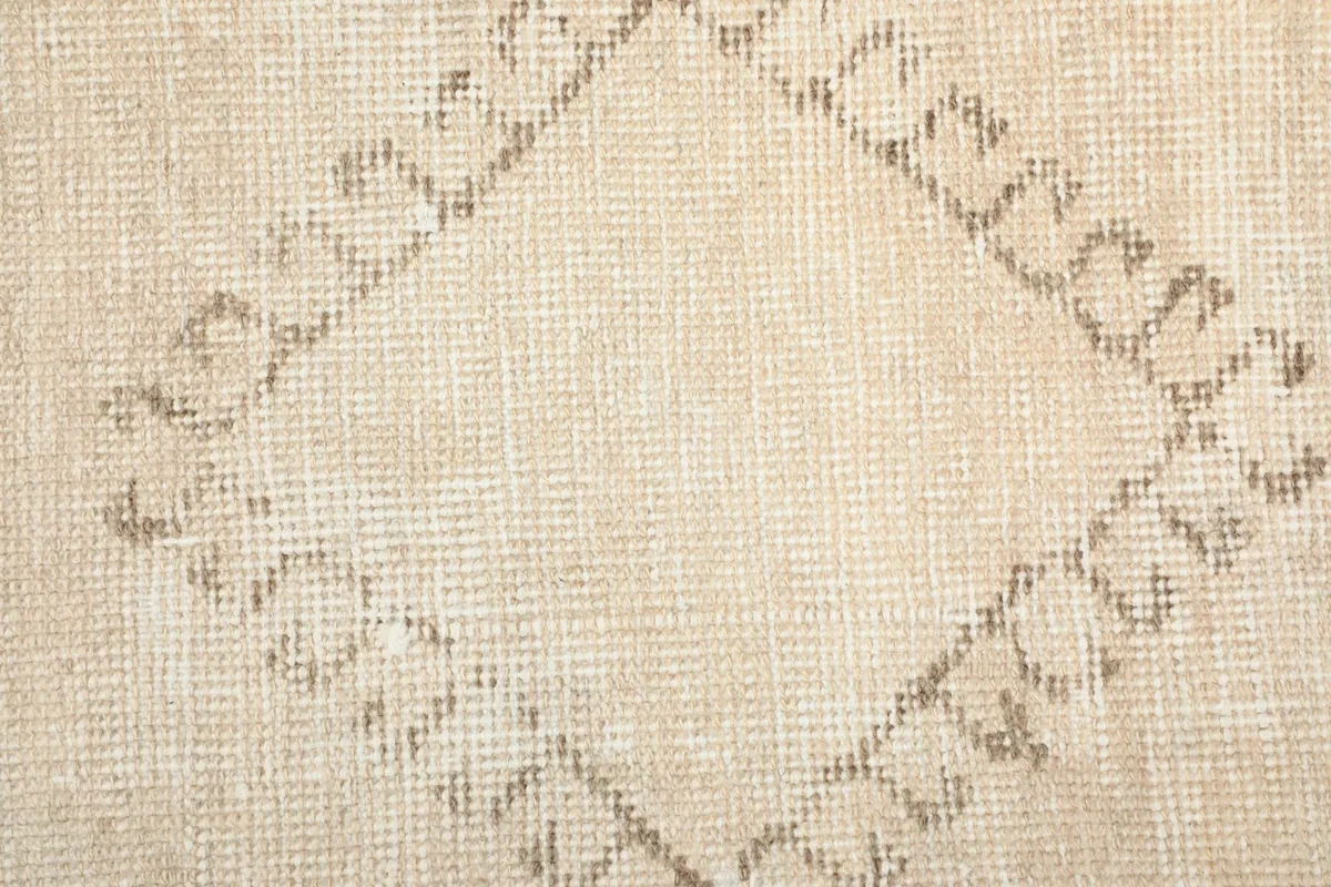Texture close-up of the low wool pile and a brown diamond geometric pattern