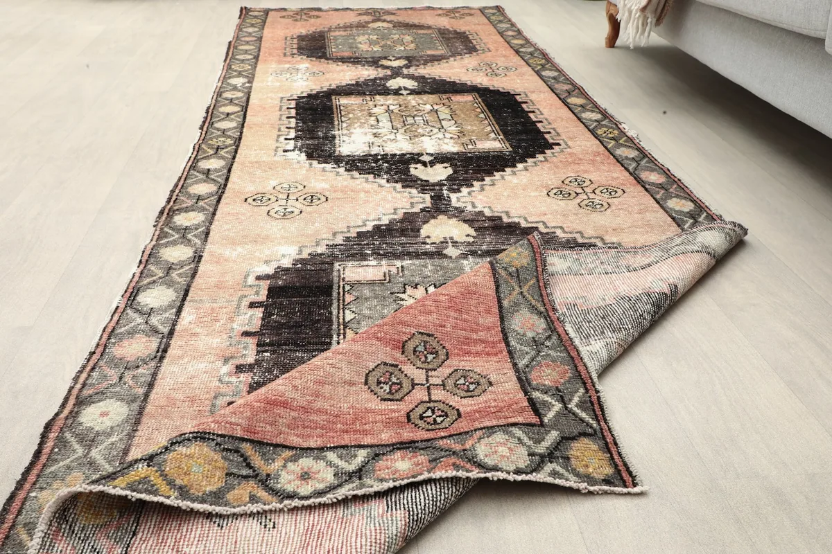 Runner rug partially folded, showcasing the full design and flexibility of the vintage wool