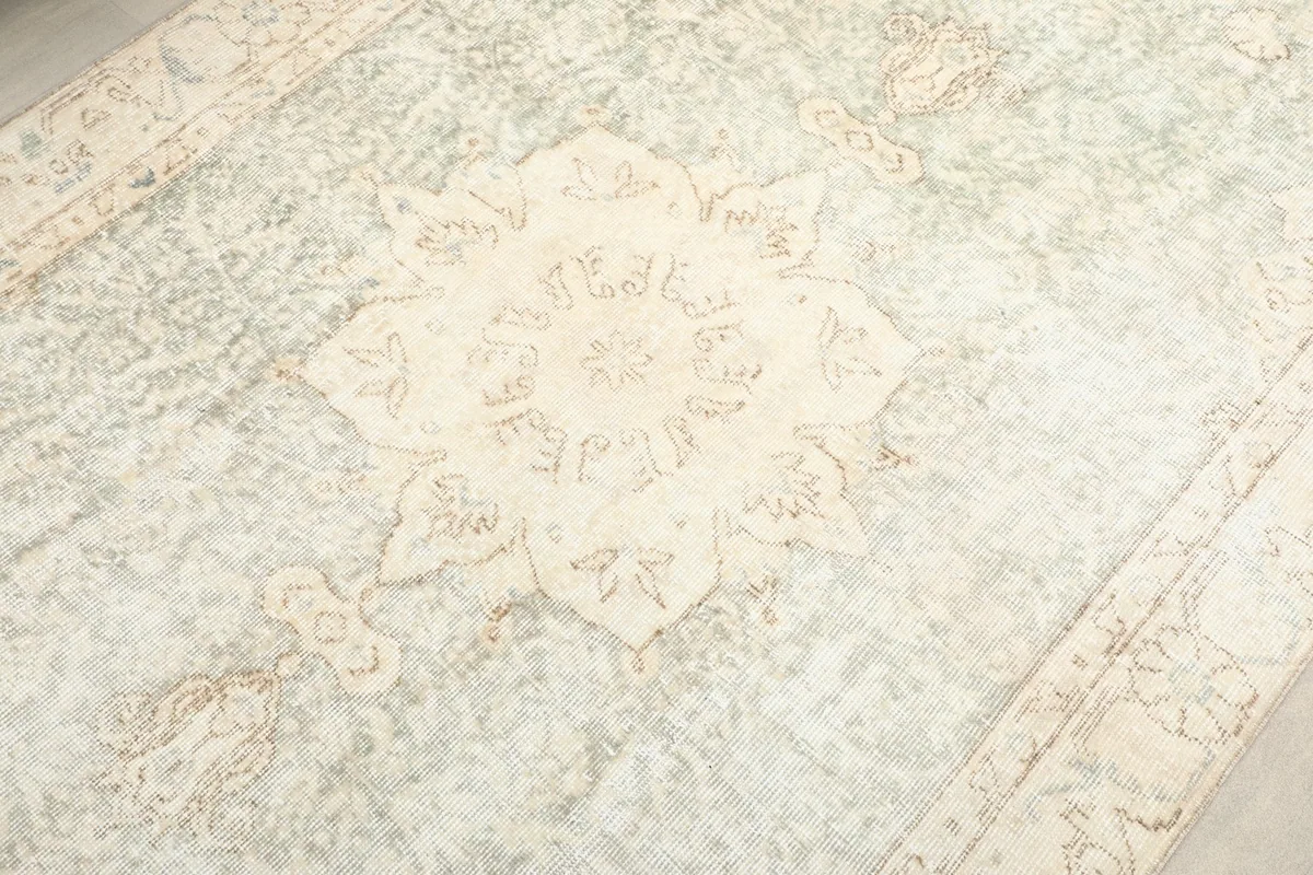Detailed shot of the central medallion pattern and surrounding faded motifs