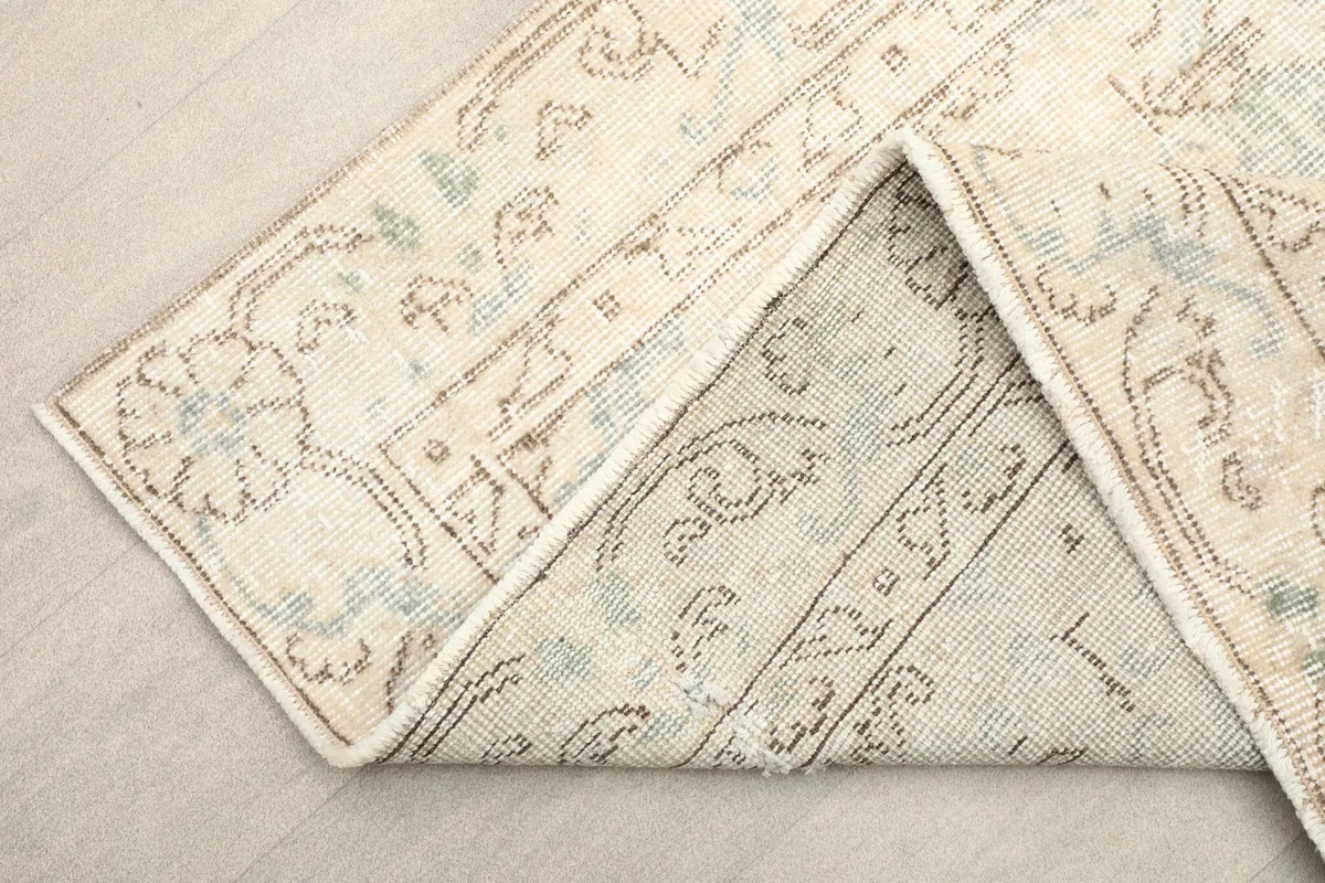 View of the rug folded to show the hand-knotted construction and back of the rug