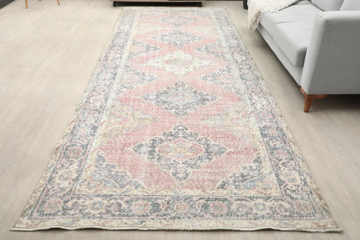 Vintage Anatolian runner rug laid out in a living room setting with a sofa