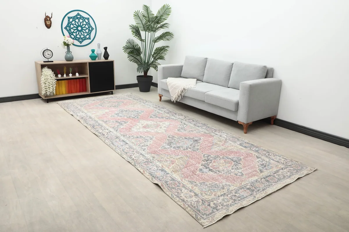 Long view of the rose and gray runner rug in a room, showcasing its length and pattern