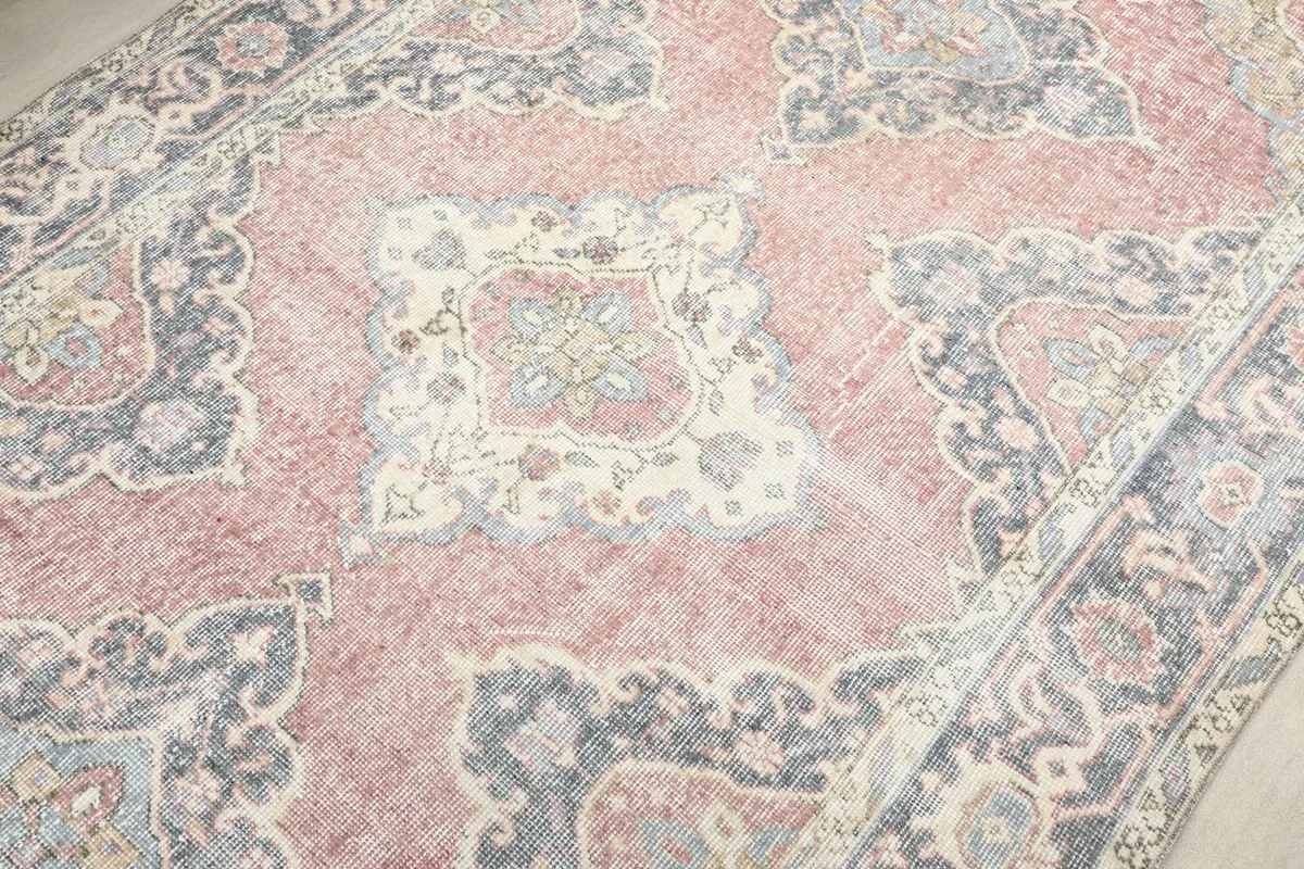 Close-up on a central medallion, showing the intricate details and faded rose tones