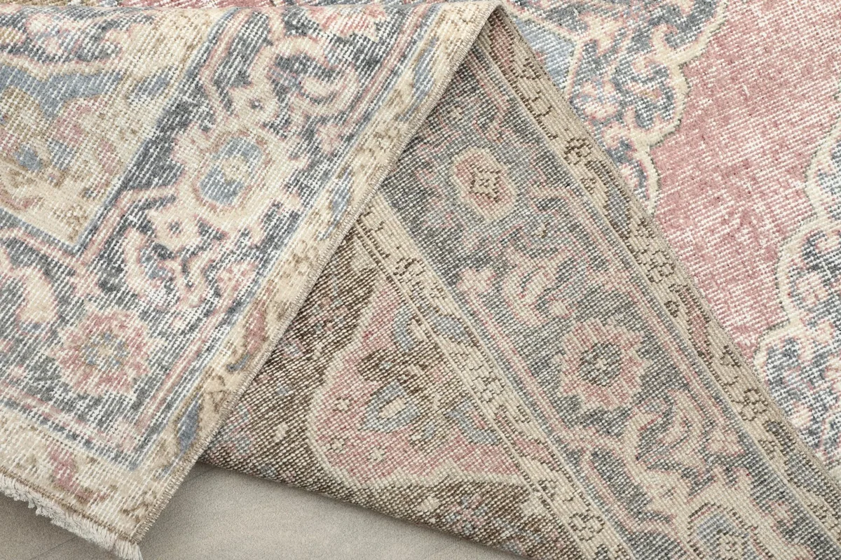 Underside of the rug showing the hand-knotted cotton foundation and reverse of the pattern
