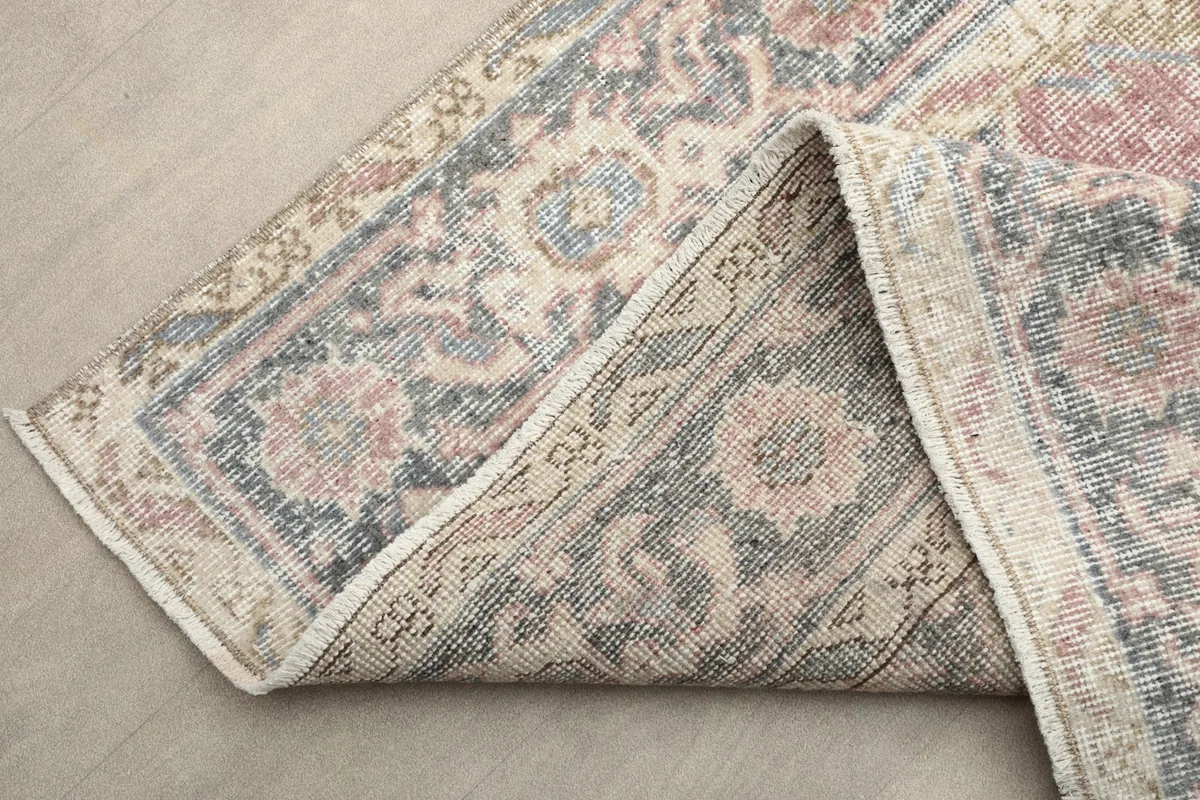 Folded corner of the rug revealing the tightly hand-knotted wool pile and cotton foundation