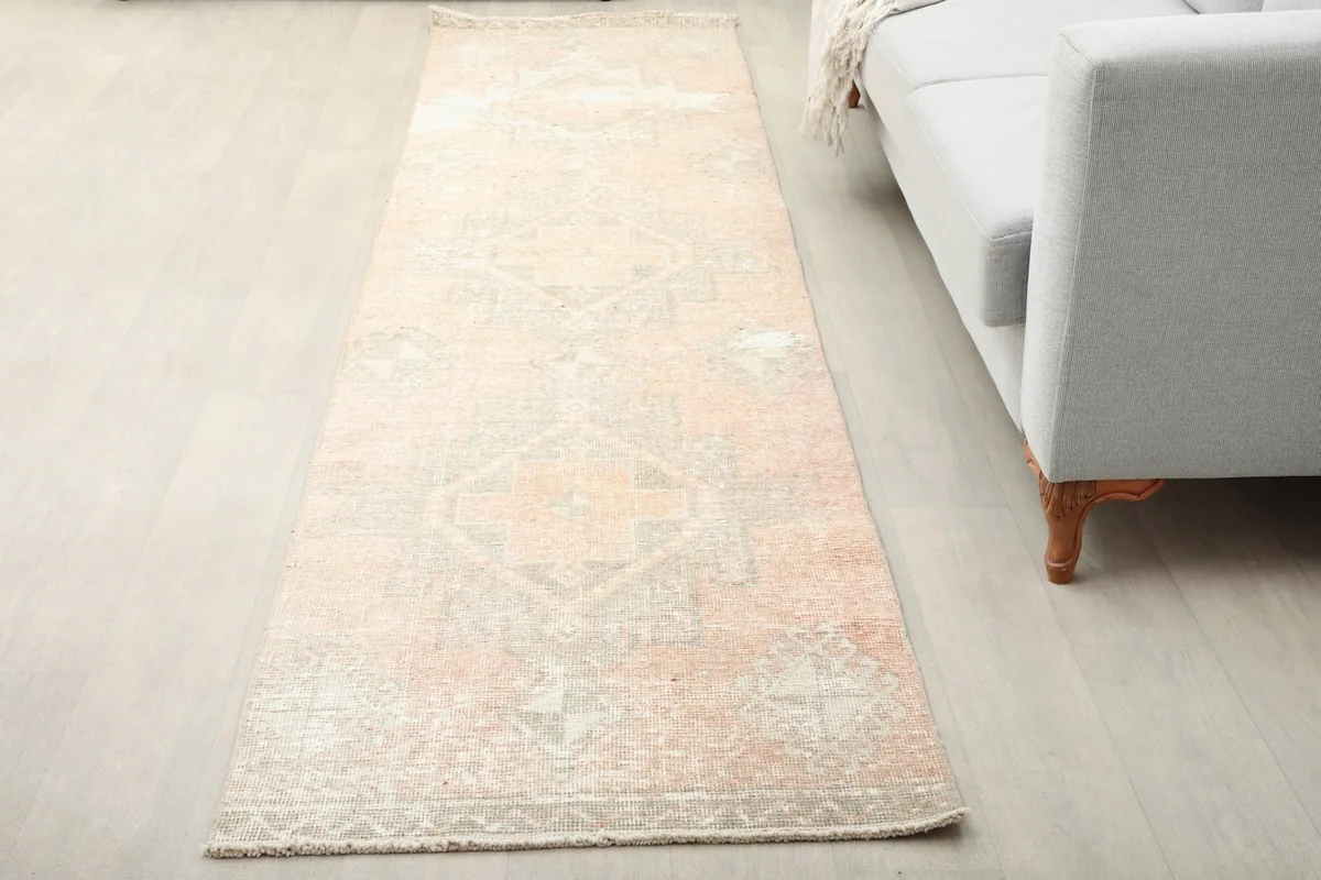 Vintage runner rug in a living room setting next to a light gray sofa
