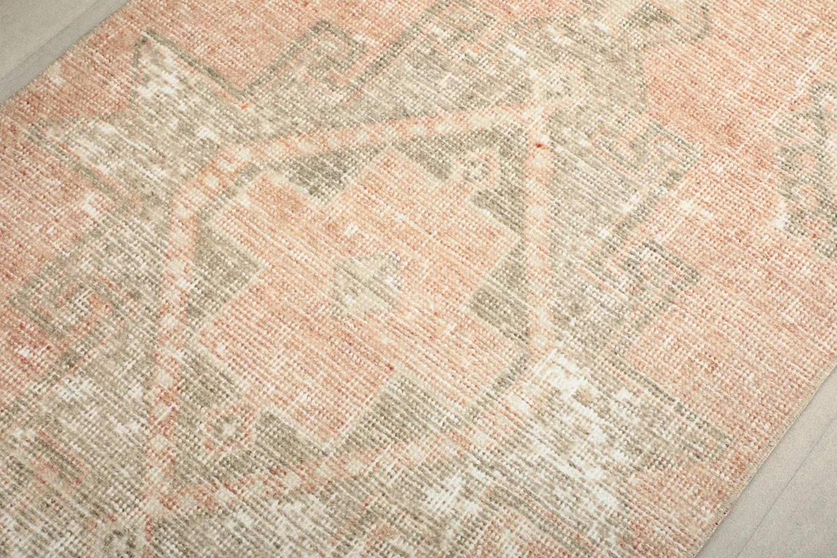 Close-up of a central geometric motif in rose, gray, and cream tones