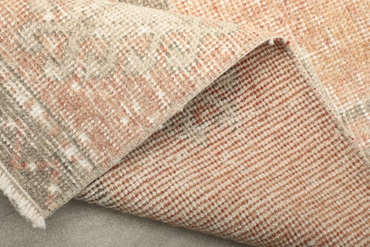 Another view of the folded rug, highlighting the back weave and foundation