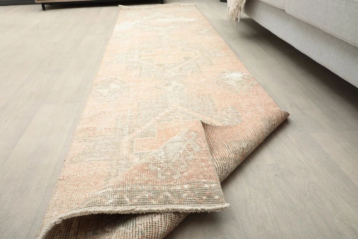 Runner rug partially unrolled on a wooden floor, showing its flexibility