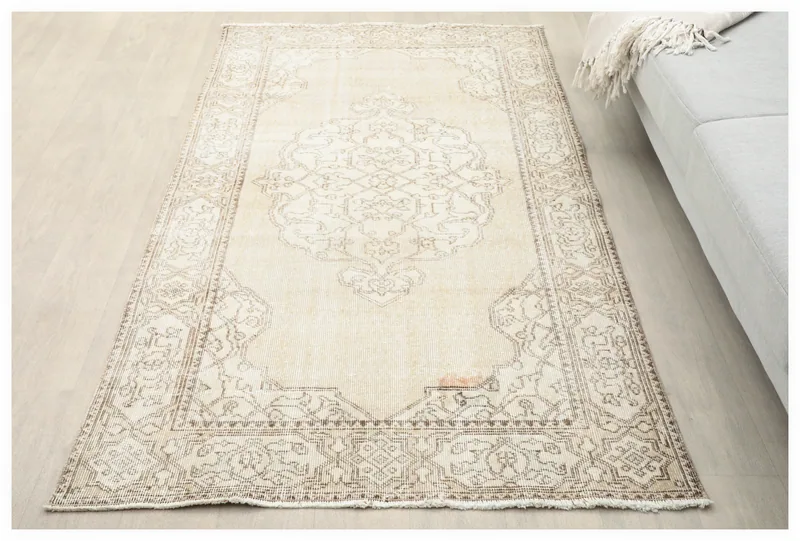 Full top view of the ivory geometric medallion vintage rug on a light background.