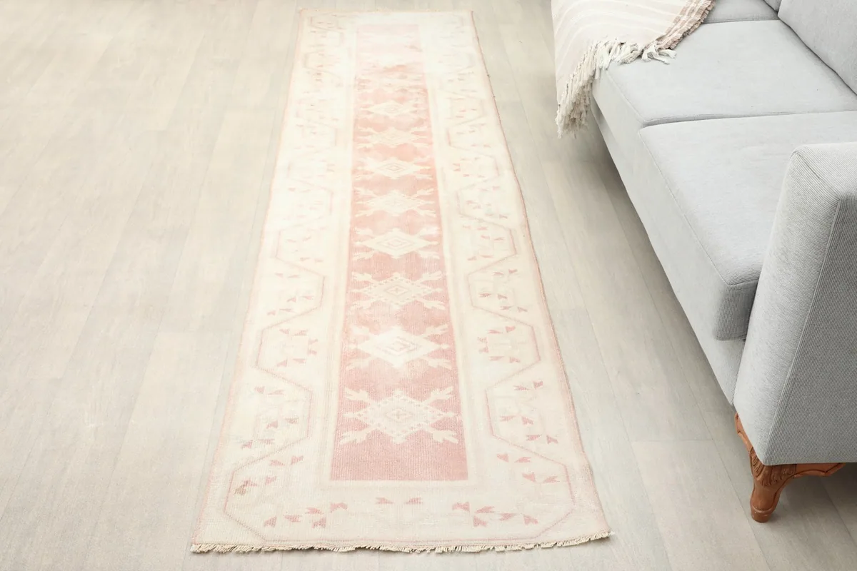 Anatolian runner rug in a room setting next to a light gray sofa, showing its length