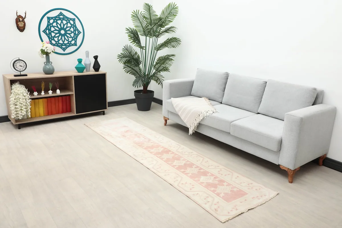 Runner rug placed in a living area with a sofa and side cabinet, showing overall decor integration