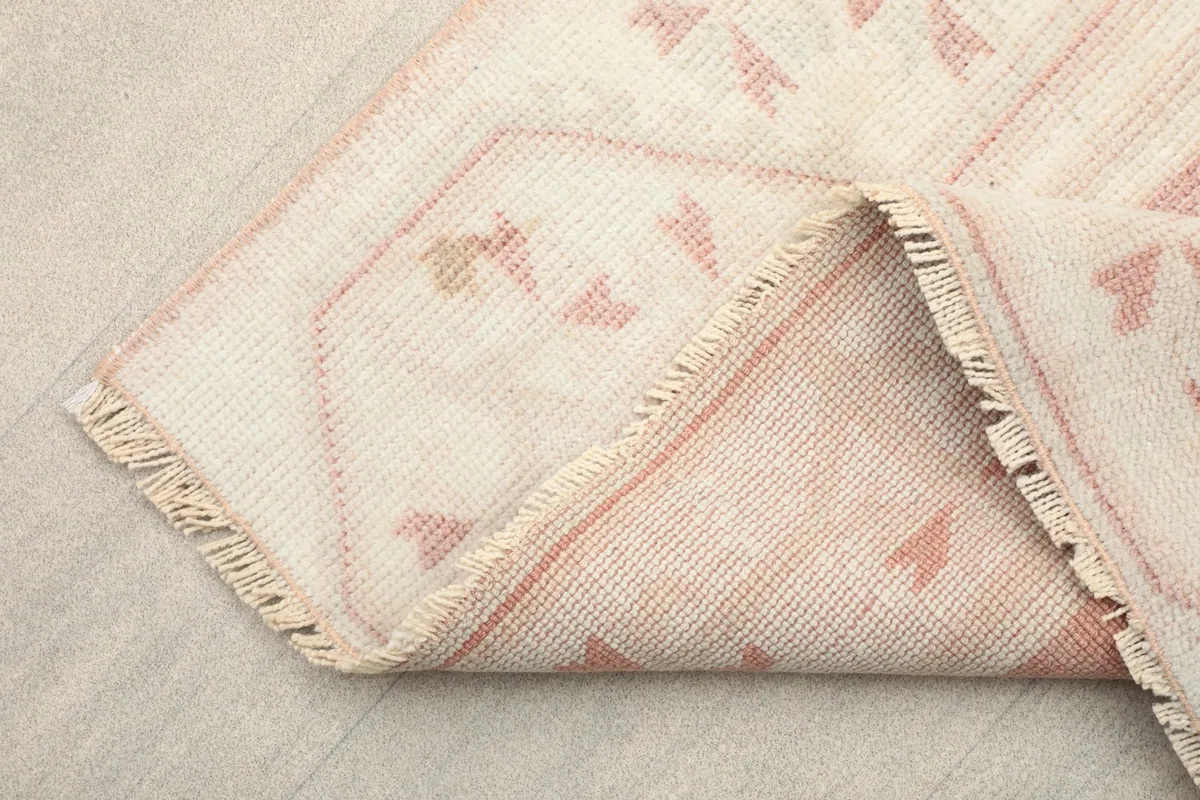 View of the rug's underside and fringe, showing the cotton foundation