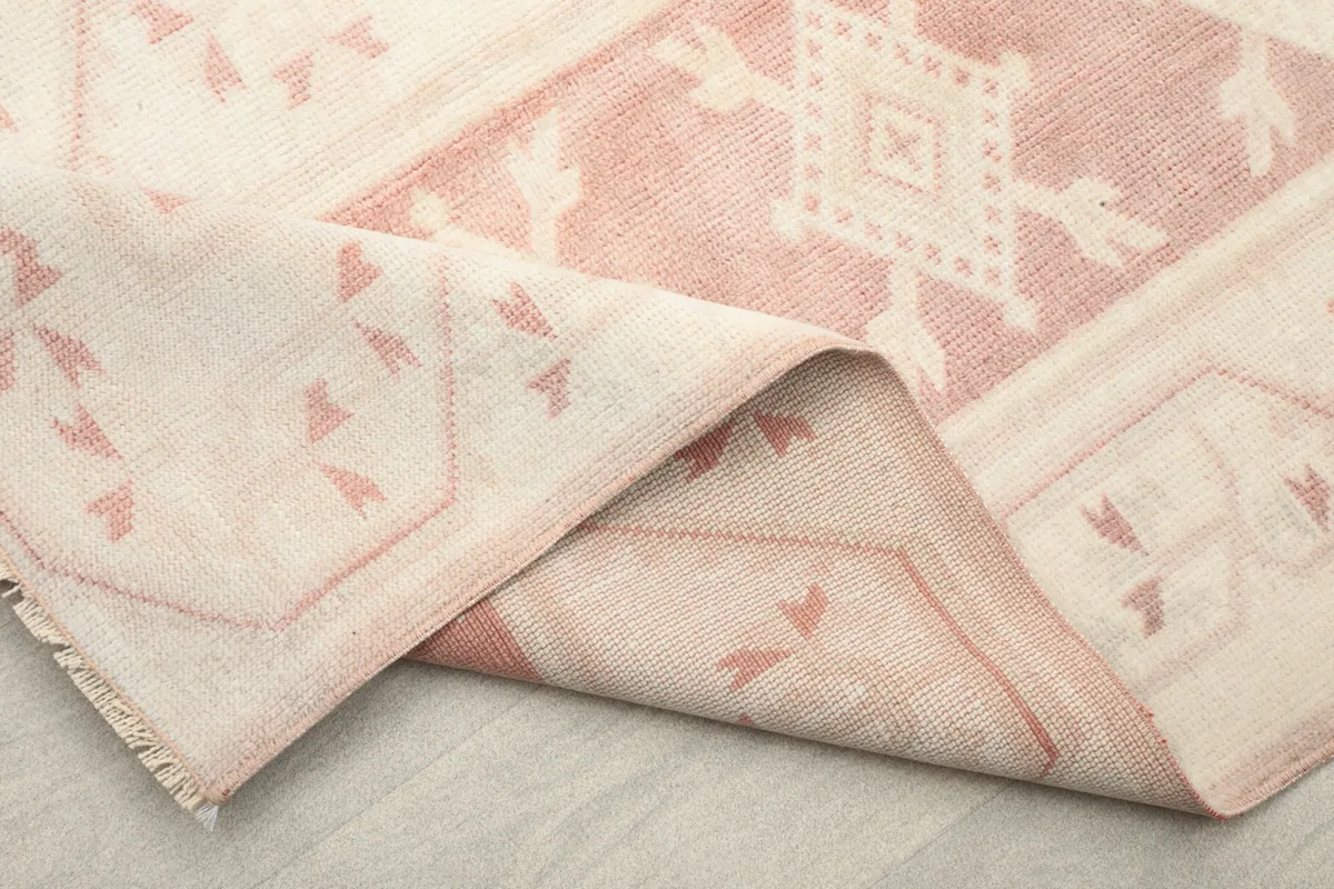 Close-up of a folded section of the rug, revealing the weave and fringe