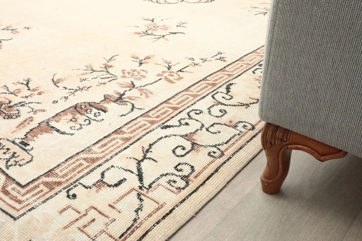 Low angle view of the rug's edge and corner, placed next to a furniture leg.