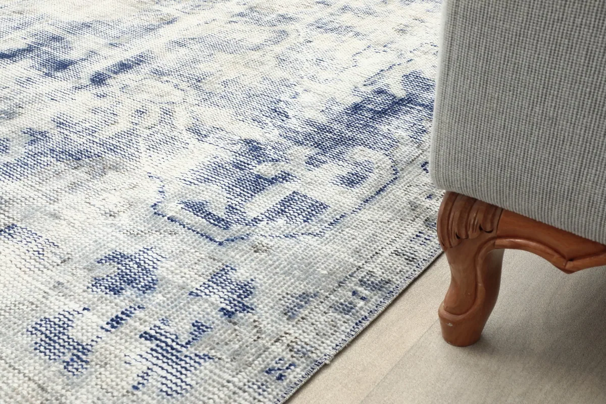 Rug detail next to a sofa leg, showing how it anchors the furniture
