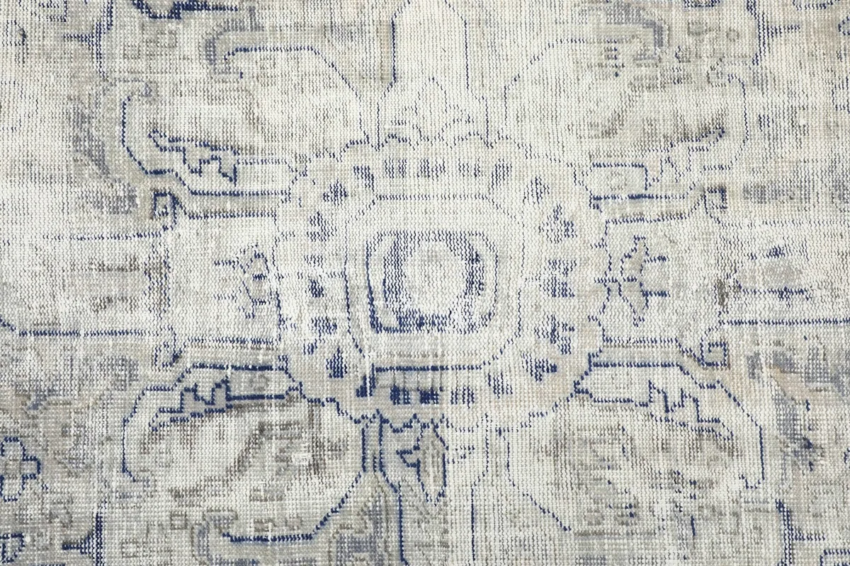 Detailed view of the central medallion motif with distressed navy and gray colors