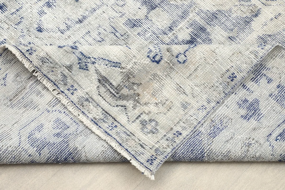 Folded corner revealing the cotton foundation and reverse side of the rug