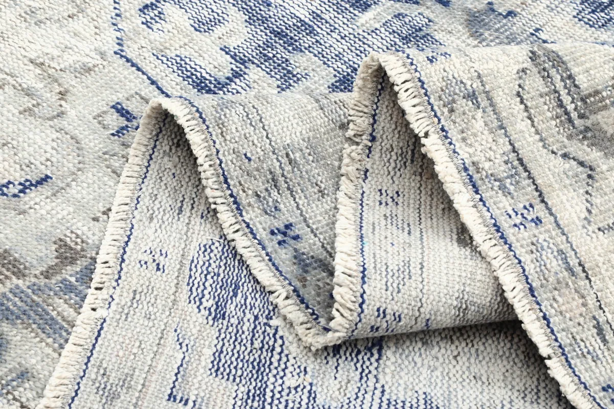 Folded rug showing the thickness of the wool pile and cotton foundation