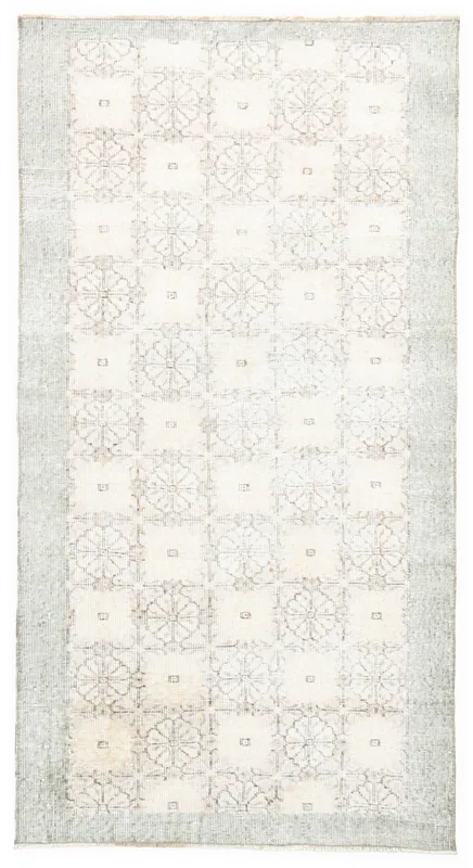 Full top view of the 3'5" x 6'8" ivory vintage rug with geometric floral pattern and gray border