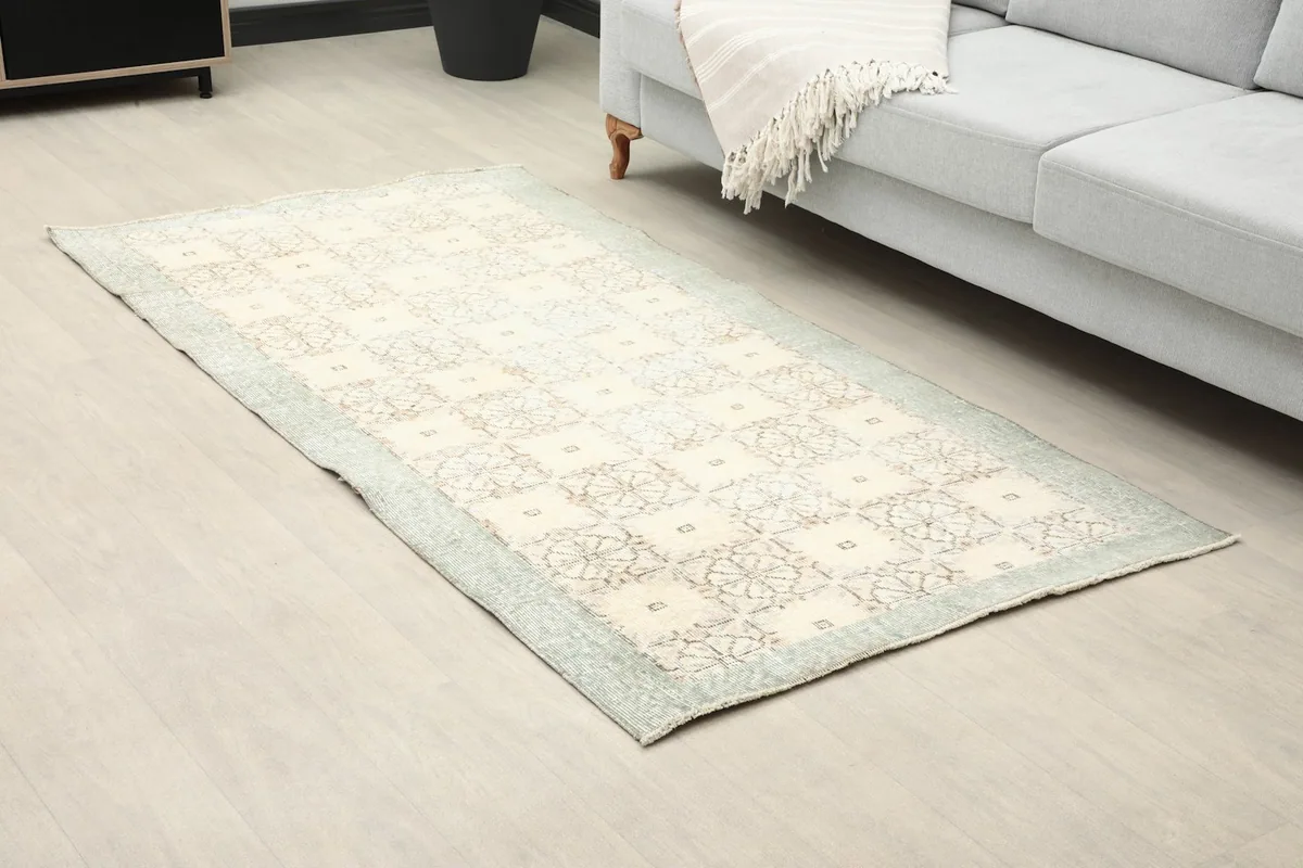 Angle view of the small vintage rug in a living room, showing its placement by a sofa