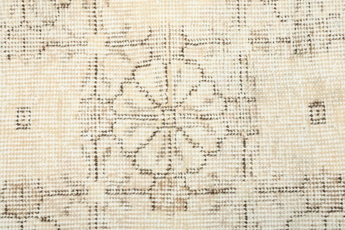 Macro detail of the hand-knotted wool pile, showing the intricate gray floral design