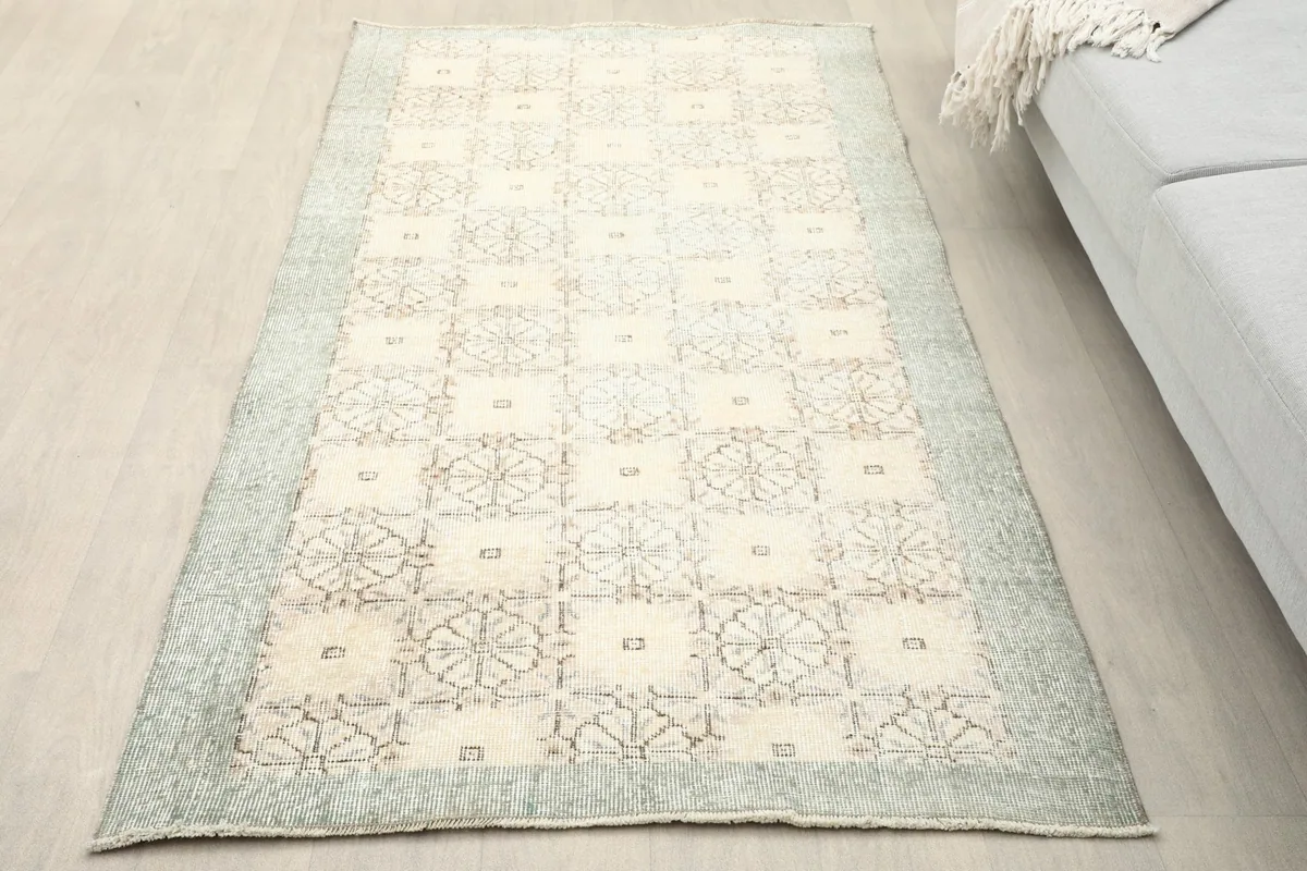 Overhead view of the ivory and gray vintage rug on a light wood floor in a room setting