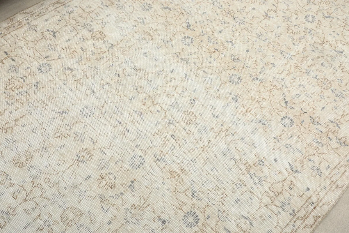 Detailed view of the rug's surface, showing the cream field and intricate floral designs.