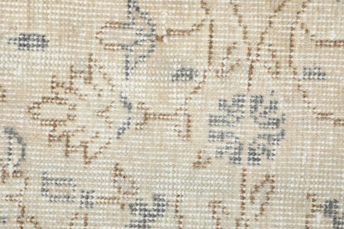 Close-up of the low wool pile, revealing the hand-knotted texture and faded colors.