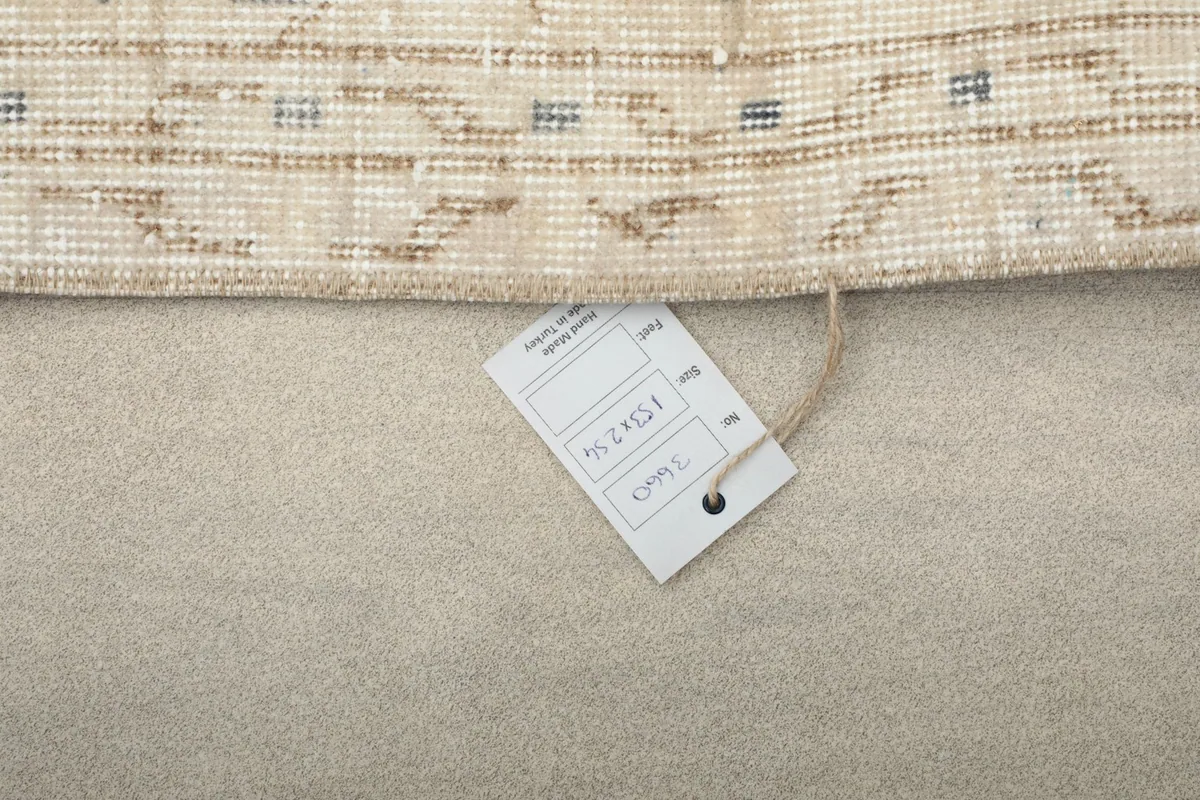 Tag attached to the rug's corner, displaying product details and origin.