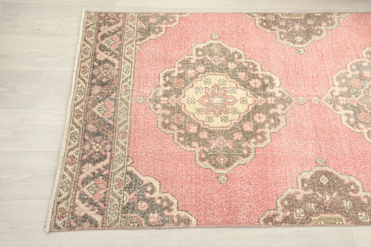 Detailed angled shot of the rose runner rug's design, highlighting the repeating medallion motifs and border.