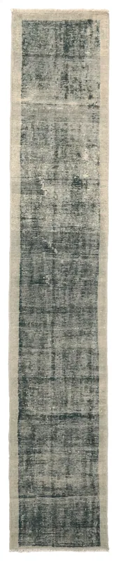 Full overhead view of the green and beige distressed vintage runner rug on a white background.