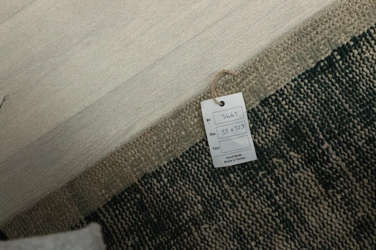 Close-up of the product tag attached to the rug, showing size details and origin.