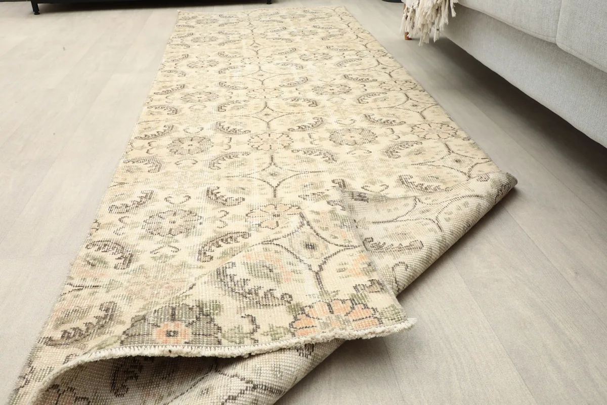 Perspective view of the runner rug partially rolled, showing its length and material