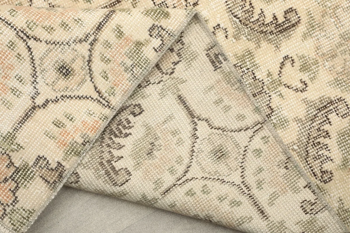 View of the rug's reverse side, showing the tightly woven cotton foundation and knot work