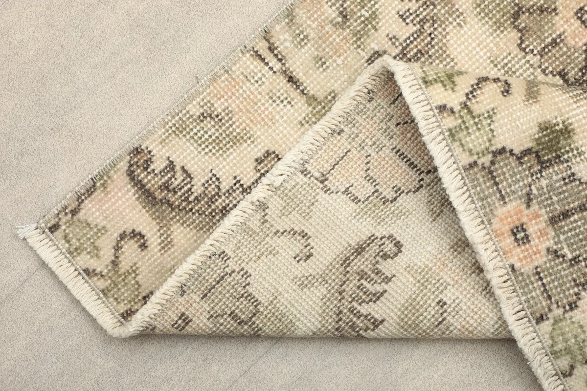 Folded corner of the rug revealing the back of the hand-knotted cotton foundation