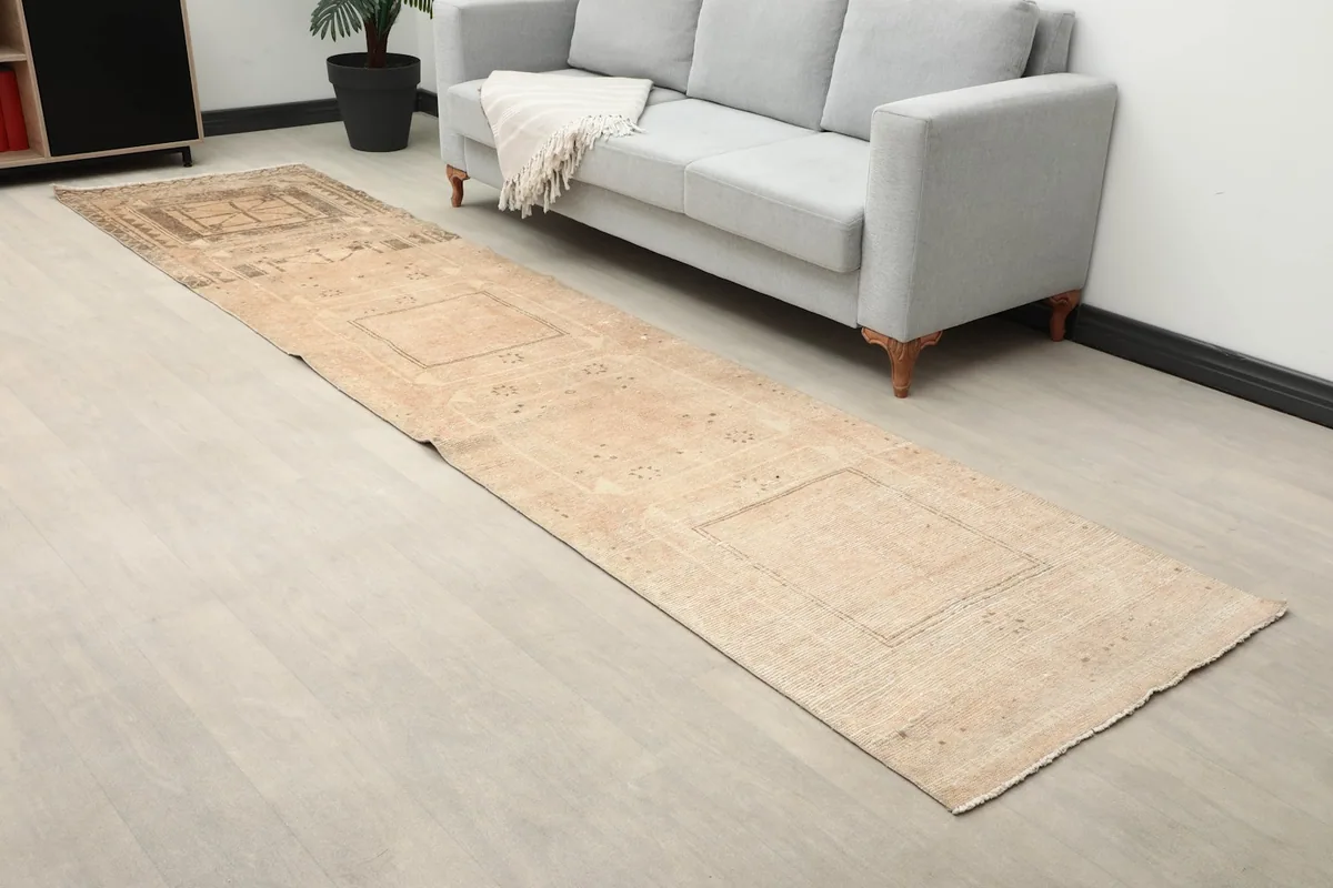 Angled view of the runner rug showing its length in a room with a light gray sofa