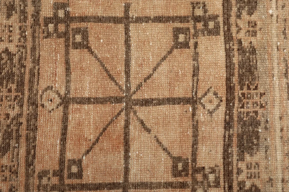 Detailed view of the intricate brown and charcoal tribal pattern at the top of the runner