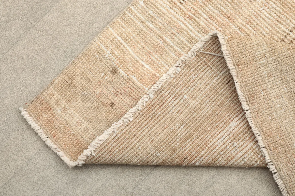 View of the reverse side of the hand-knotted wool rug, showing the cotton foundation