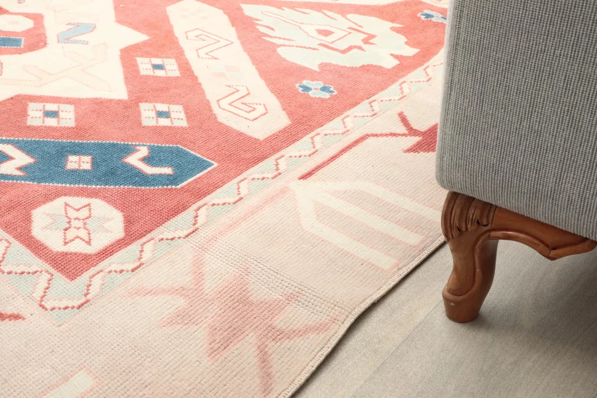 Close-up of the rug's low pile surface and the detailed patterns next to a sofa leg