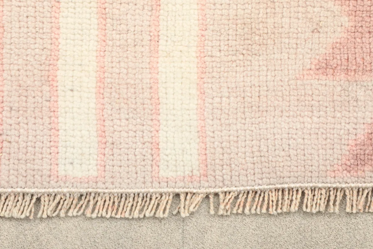 Close-up of the fringe and edge of the vintage Anatolian rug, showing its hand-knotted craftsmanship