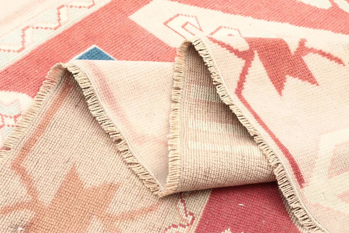 View of the rug's reverse side and folded edge, showing the tight hand-knotted weave