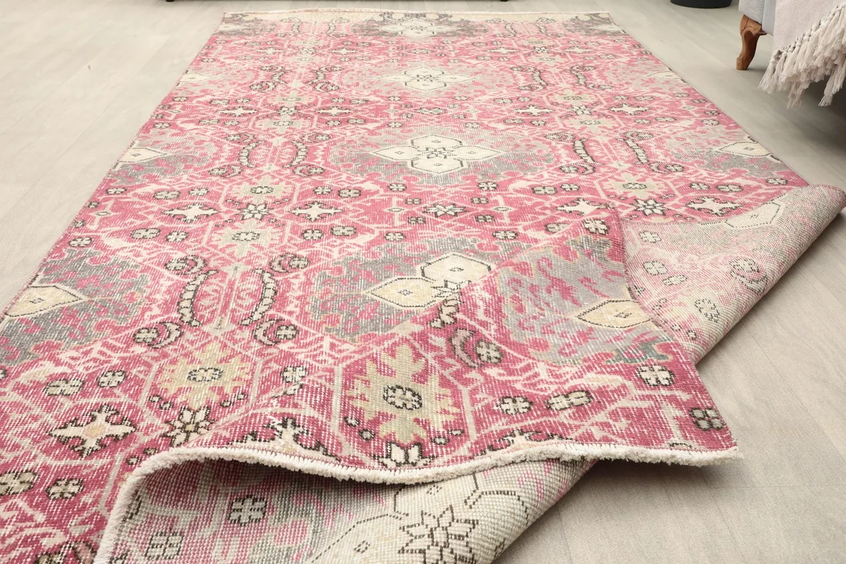 Close-up of the low wool pile and the worn surface texture of the vintage rug